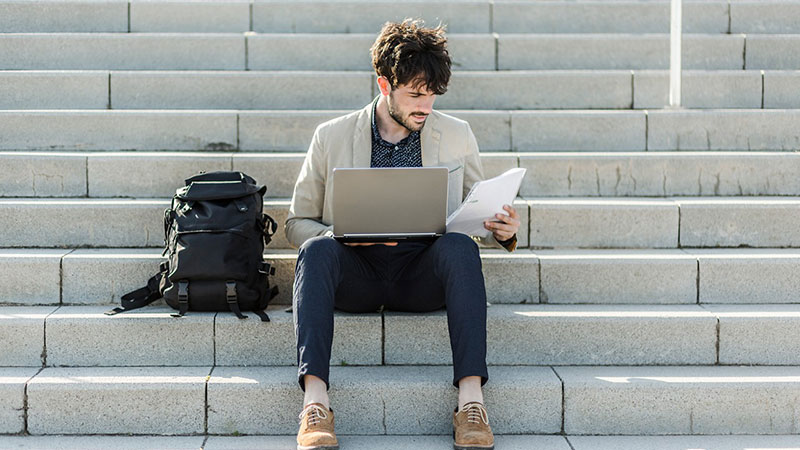student-on-steps-on-laptop